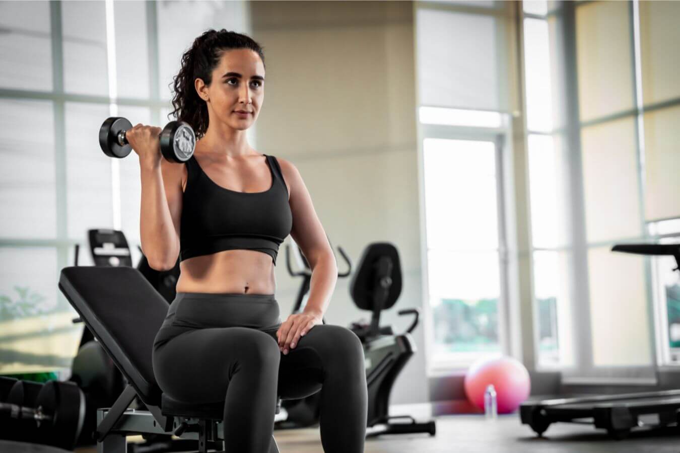 Mujer levantando pesas en su sesión de entrenamiento personal
